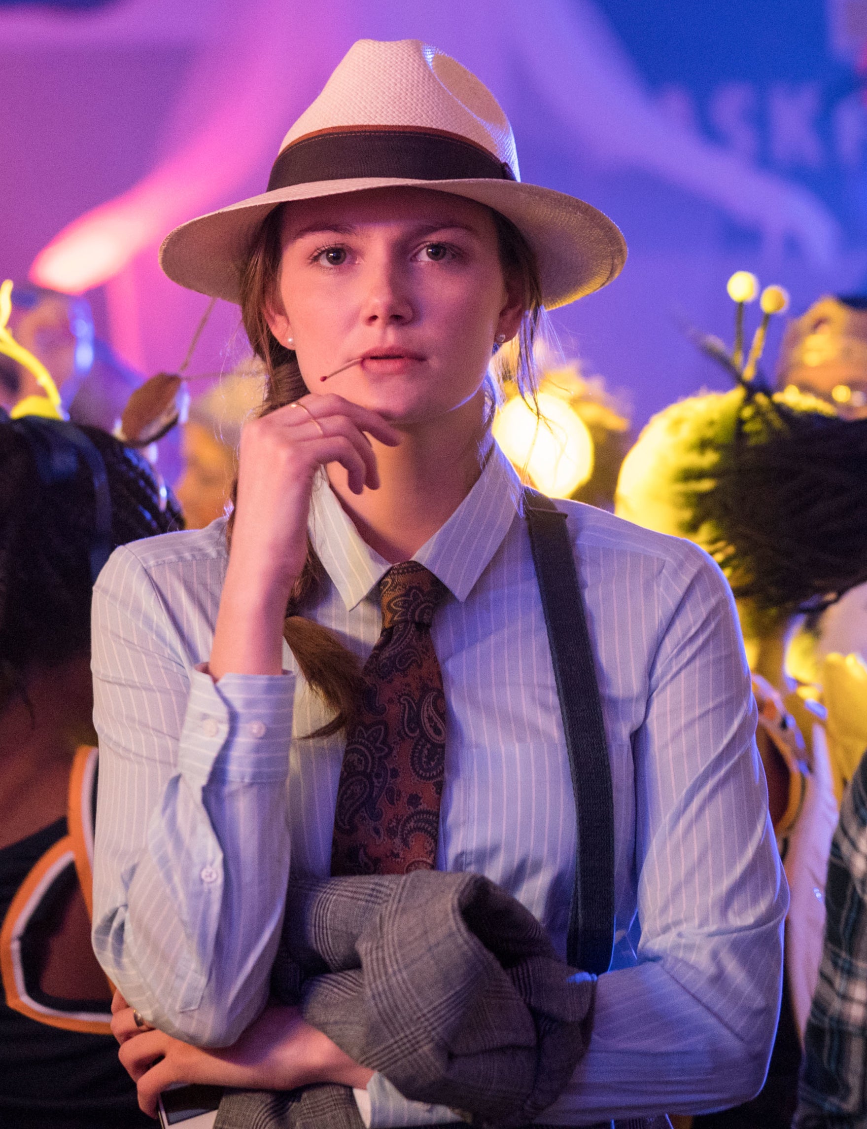 Andi Matichak wearing a fedora, suspenders, and a pinstripe button-up shirt in "Halloween"