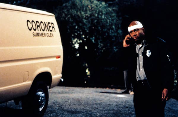 LL Cool J dressed as a cop wearing a white bandage as he talks on the phone next to a coroner&#x27;s van in &quot;Halloween H20: 20 Years Later&quot;