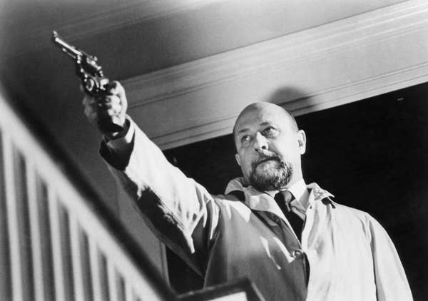 Donald Pleasance wearing a trench coat while pointing a gun in &quot;Halloween&quot;