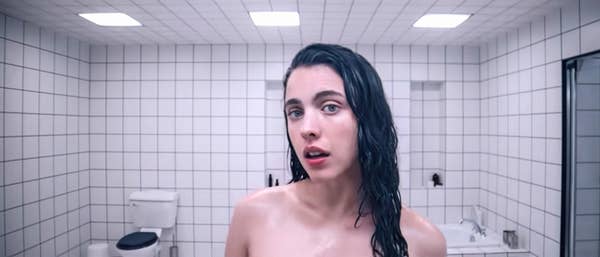 I don’t know who this person is. They are in a tiled bathroom, with slicked back wet hair, looking into the camera