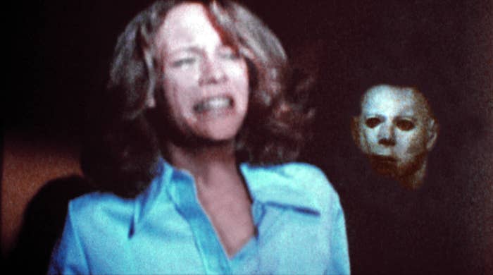 Jamie Lee Curtis with a terrified expression and Michael Myers standing behind her in &quot;Halloween&quot;