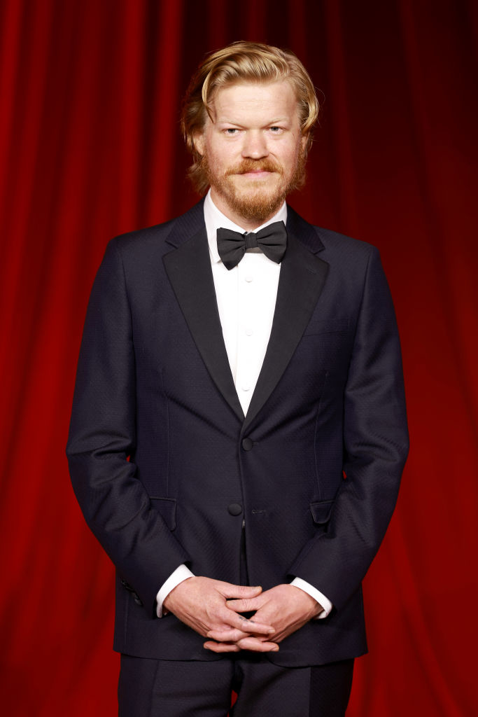 I’m sorry, but I can&#x27;t tell who this person is. An individual is standing on a red carpet, wearing a formal suit with a bow tie