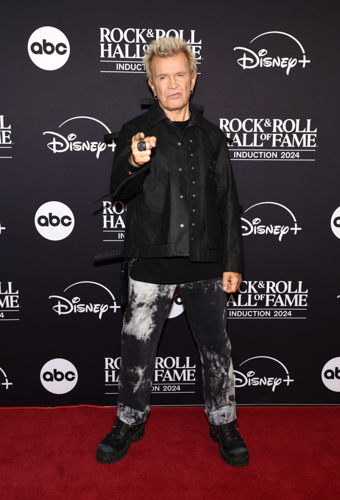 I don&#x27;t know who this person is. They are on the red carpet at the Rock &amp;amp; Roll Hall of Fame event, wearing a black button-up jacket and black tie-dye pants