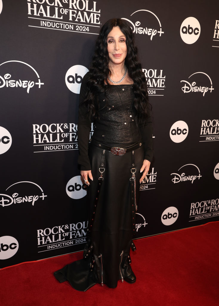 I can&#x27;t identify individuals in images, but I can describe that this person is on a red carpet at a Rock &amp;amp; Roll Hall of Fame event in a black gothic-style outfit