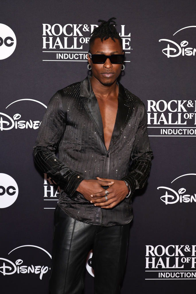 I don&#x27;t know who this is. The person is wearing a stylish outfit with a deep V-neck shirt and leather pants at a Rock &amp;amp; Roll Hall of Fame event