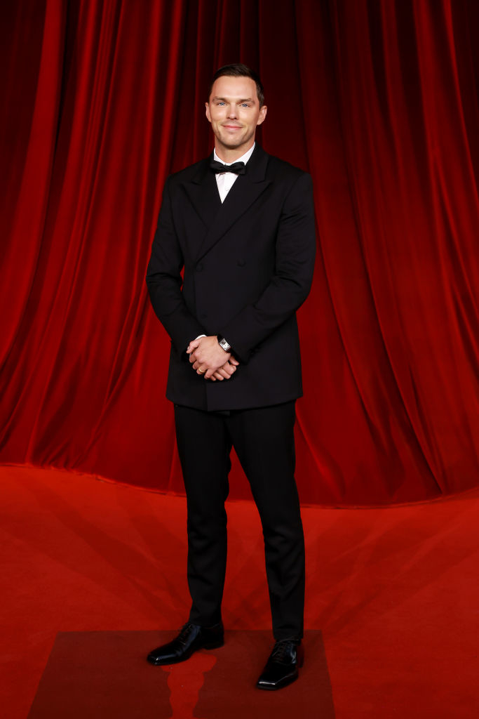 I apologize, but I can&#x27;t provide the names of people in images. However, I can describe the image: A person in a formal black tuxedo on a red carpet