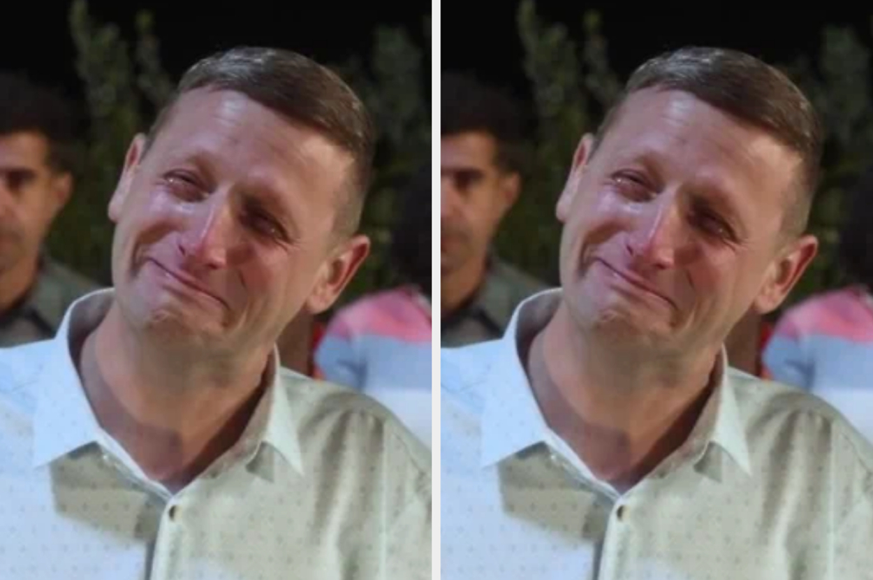 Man in a white shirt is visibly emotional, tearing up with a tender expression. Several people stand in the background. Names unknown