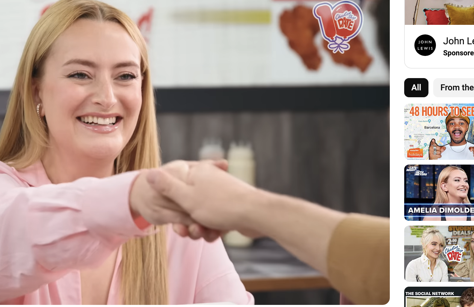 Amelia Dimoldenberg shakes hands with a guest on &quot;Chicken Shop Date.&quot; YouTube interface with video details shown