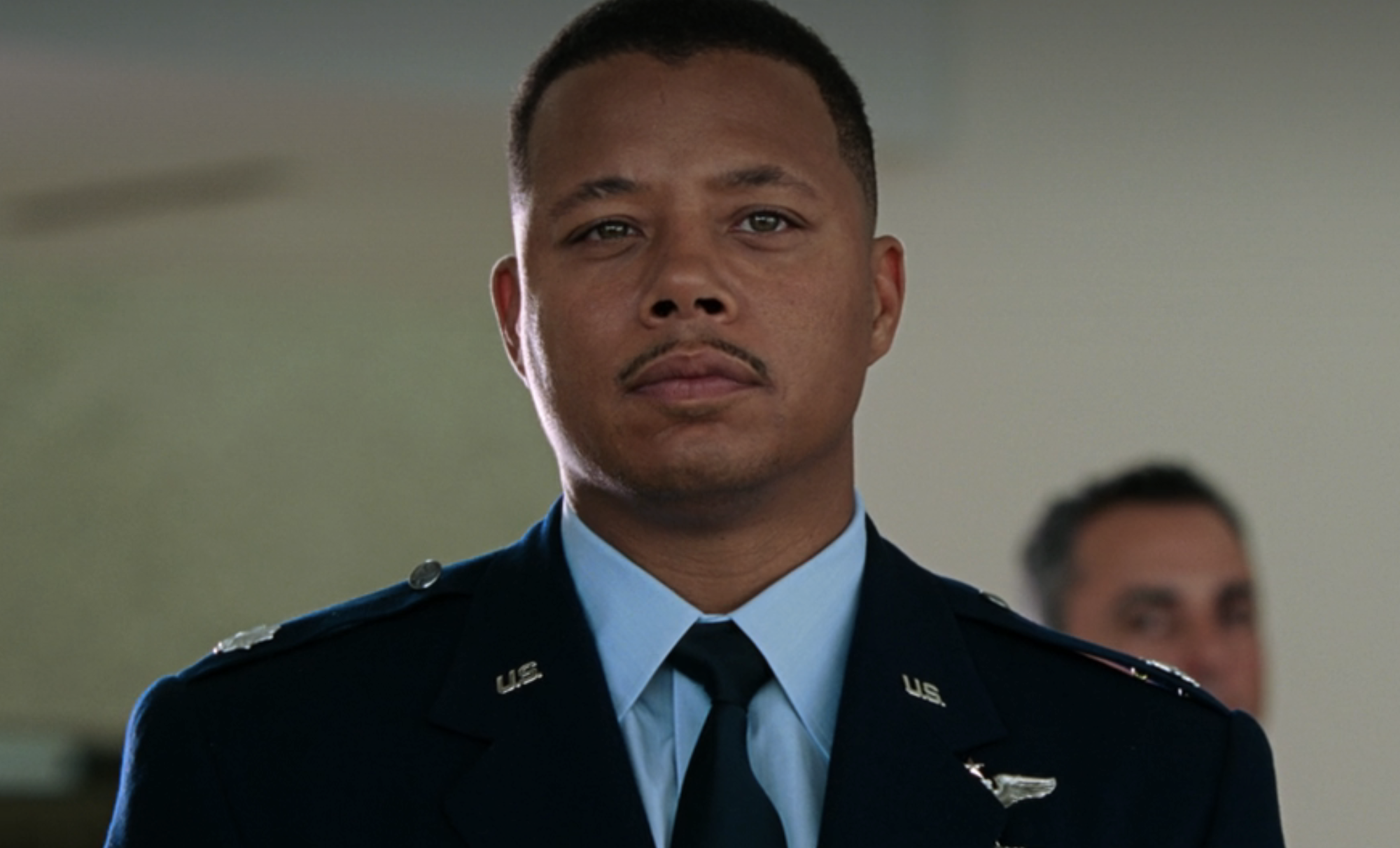 Terrence in a military uniform stands in a scene. His expression is serious, and he wears rank insignia on his shoulders