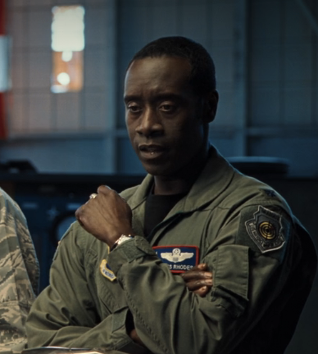 Don in military uniform with folded arms, looking serious, appearing in a scene