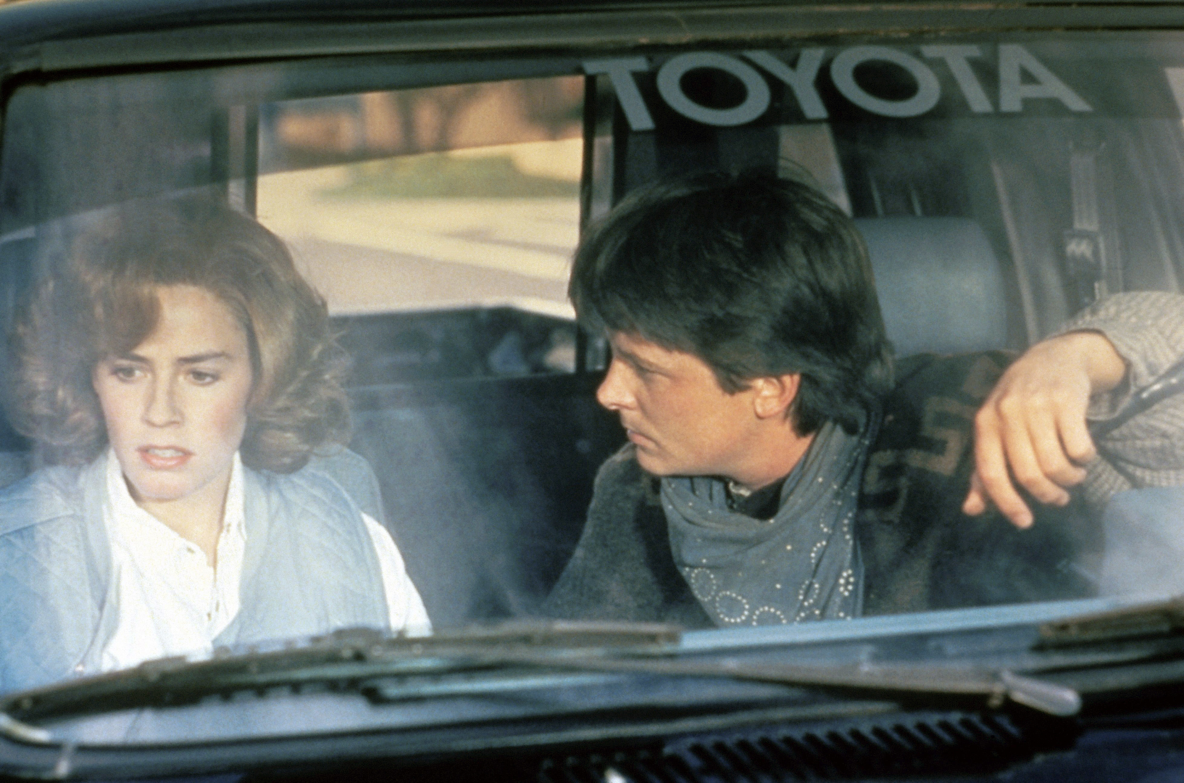 Jennifer and Marty sit in a parked car, she looks concerned while he listens attentively