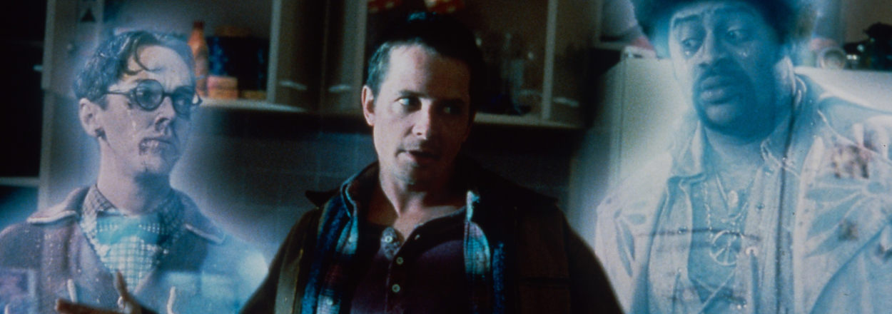 Image from the movie "The Frighteners" featuring characters played by Michael J. Fox, Jim Fyfe, and Chi McBride interacting with ghostly figures in a kitchen