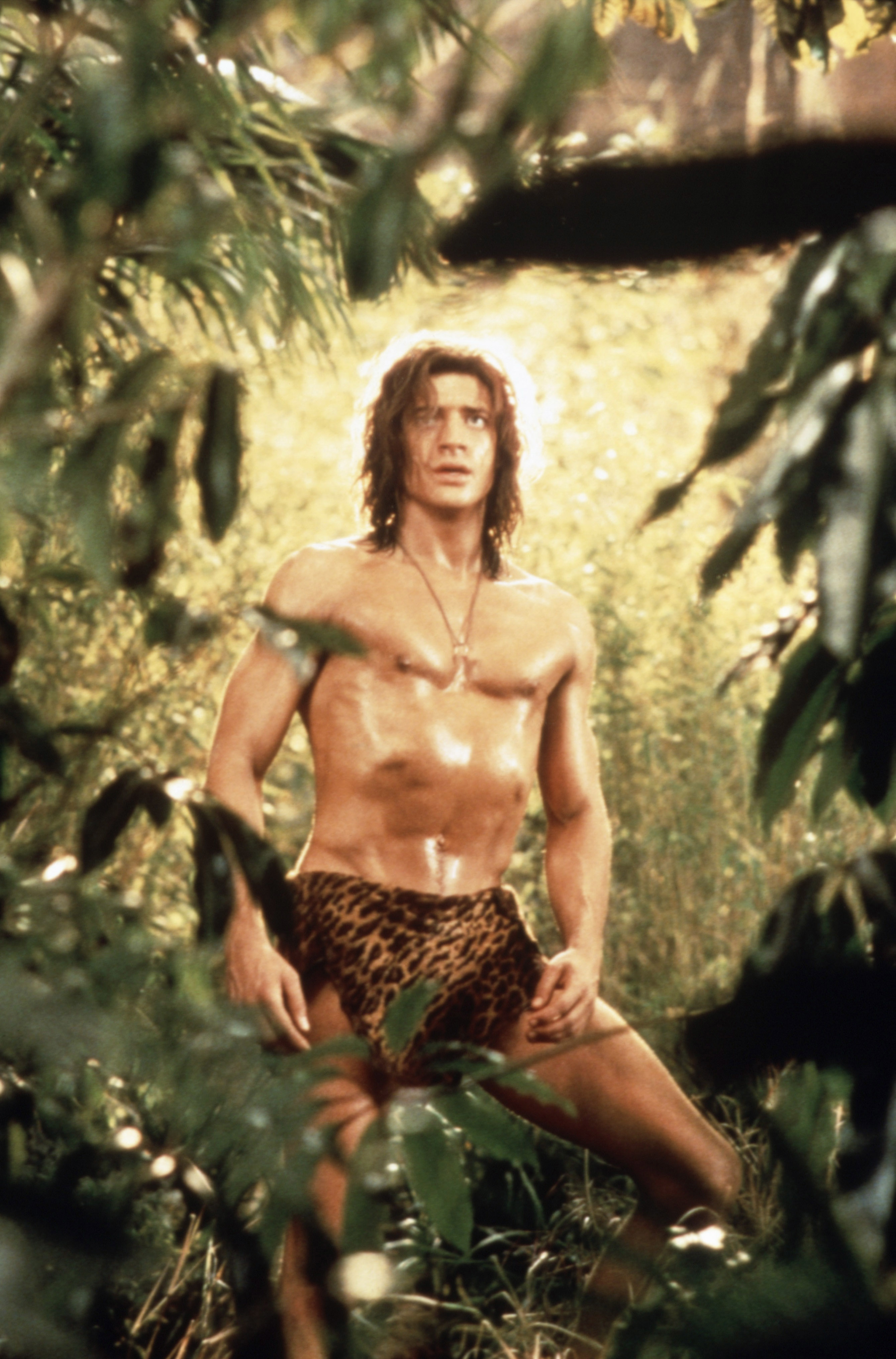 Brendan stands in a jungle setting, wearing a leopard-print loincloth