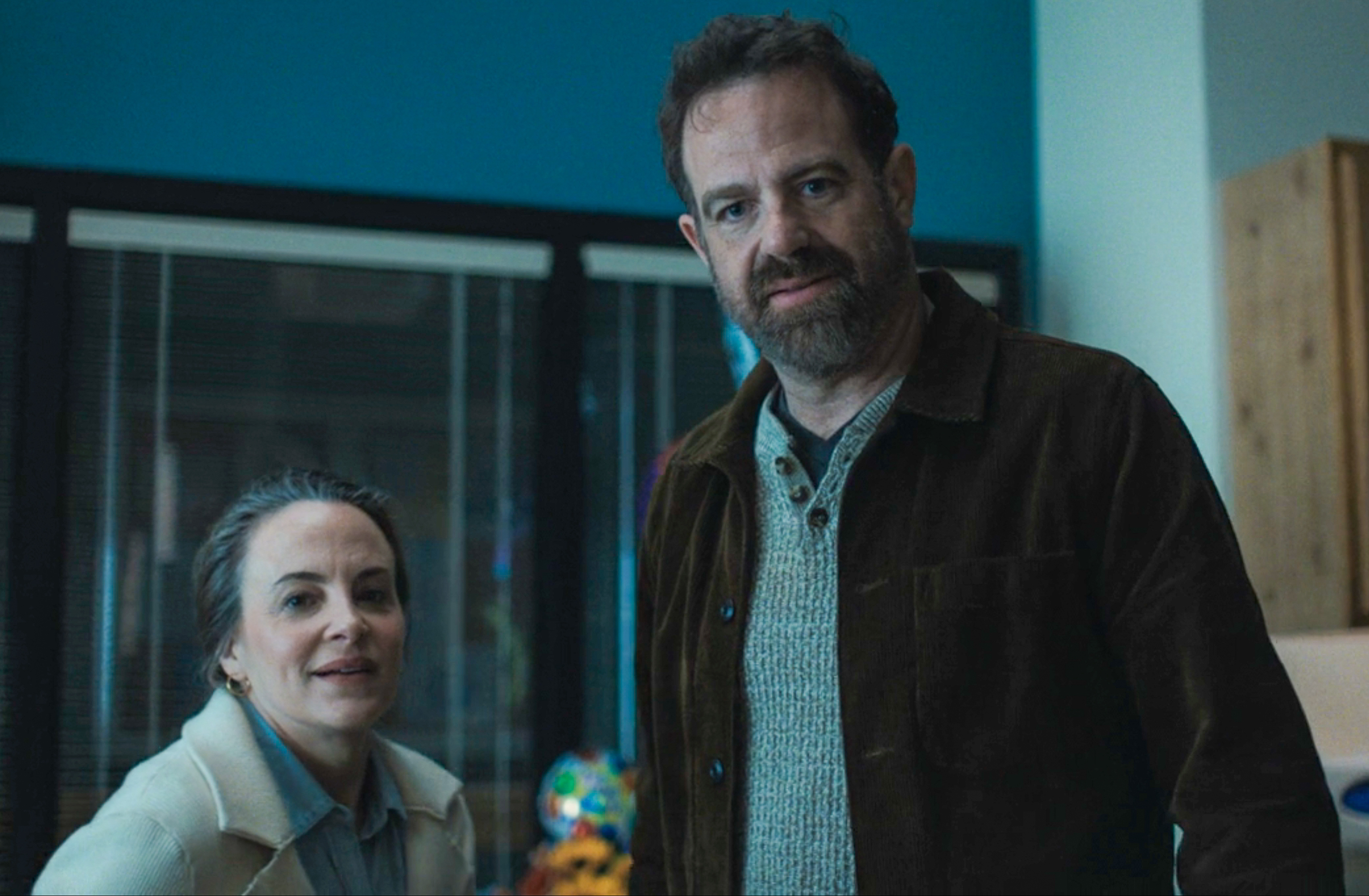 POV shot of two people in casual clothing in a hospital room looking at camera