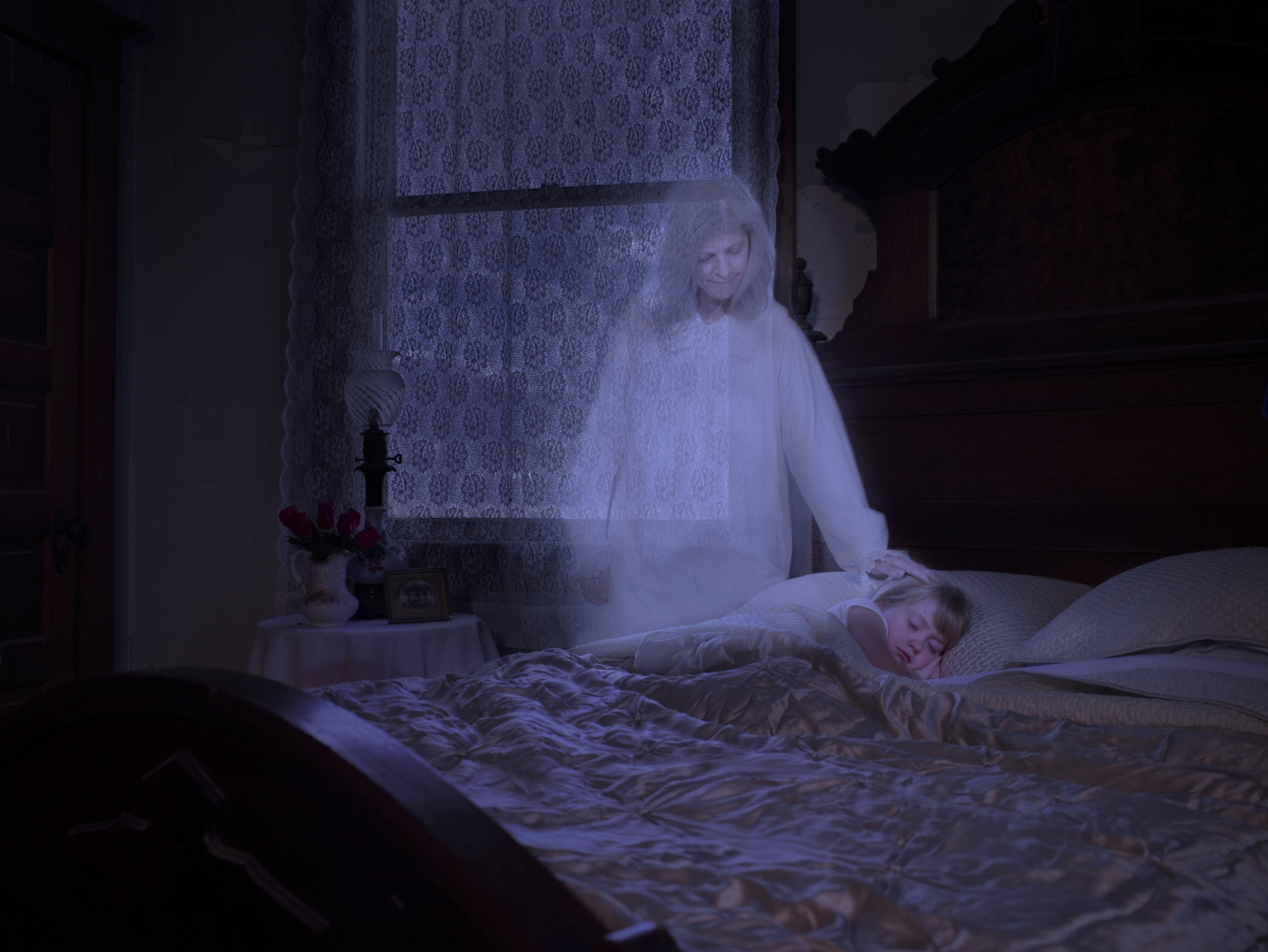 A ghostly figure touches a sleeping person in a dimly lit bedroom with a lace-curtained window