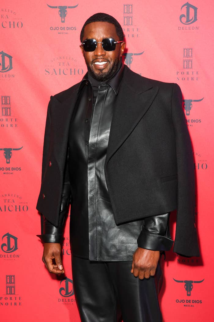 Man in black leather outfit and long coat on a red carpet