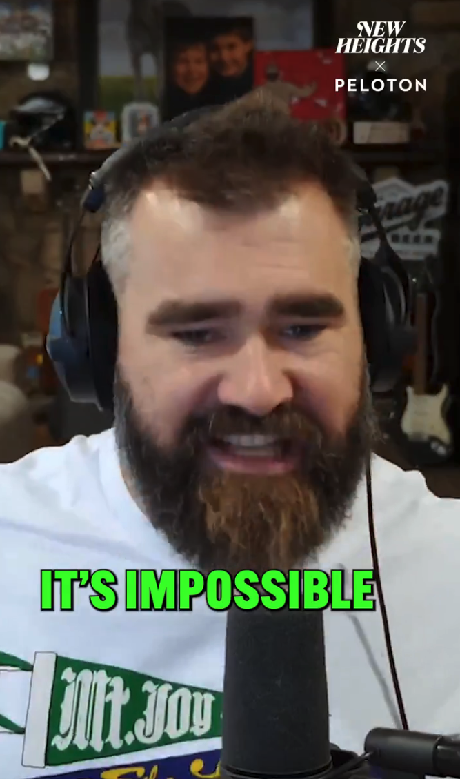 Man with a beard wearing headphones and a white graphic t-shirt, speaking into a microphone. Text reads: &quot;It&#x27;s Impossible.&quot;