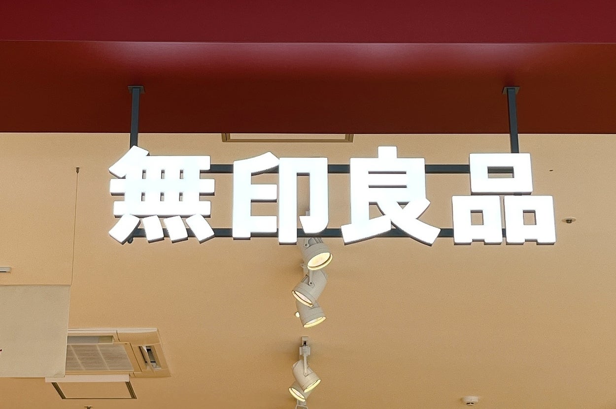 無印良品の店内看板。レディース服売り場の案内も見える。