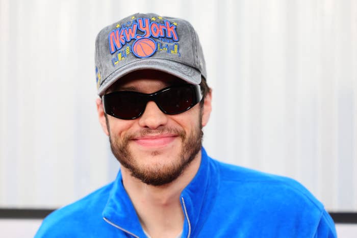 Pete Davidson in a New York cap, sunglasses, and a jacket
