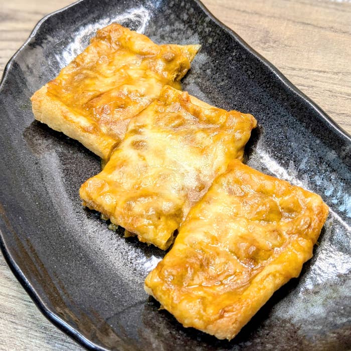 お皿に乗った焼かれた油揚げピザ3切れ。