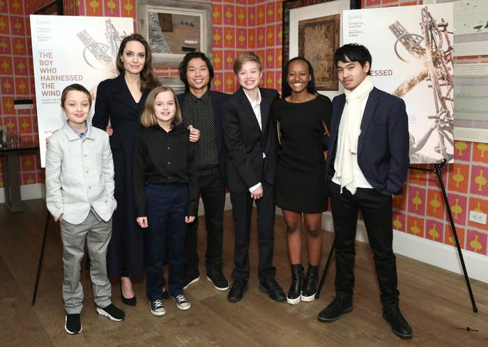 I don't know who the people in the image are, but they are standing together for a group photo at an event. They are wearing stylish formal attire