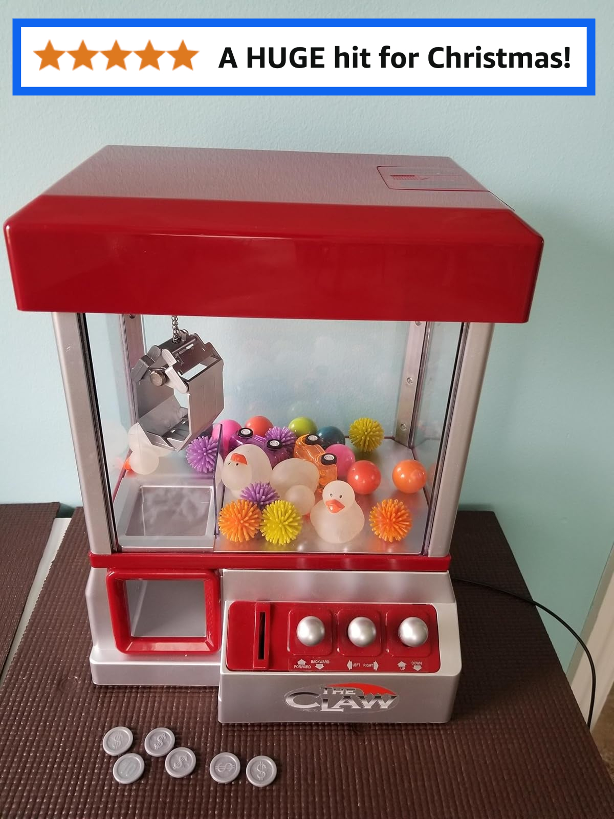 Claw machine with small plastic toys inside; five-star review states, 