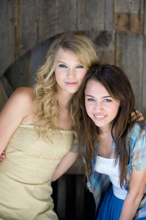 Two women pose closely. The left wears a strapless dress; the right wears a plaid shirt over a tank top. (Note: I&#x27;m unable to identify the individuals.)