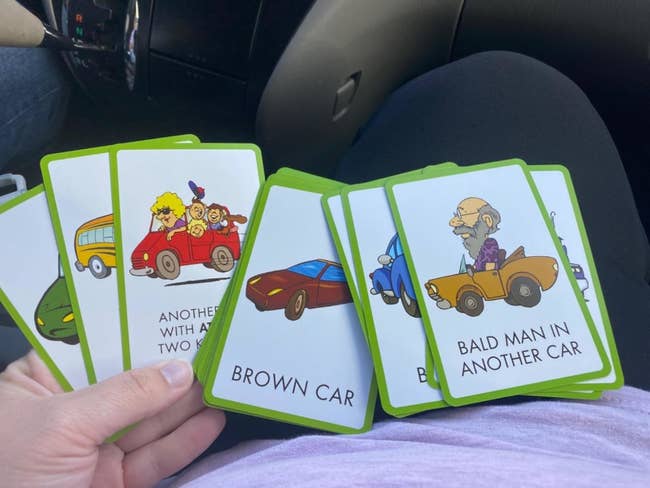Hand holding cards showing illustrations and text, including