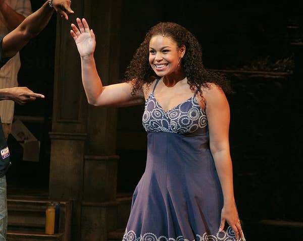 Jordin in a spaghetti strap dress, smiling and waving onstage