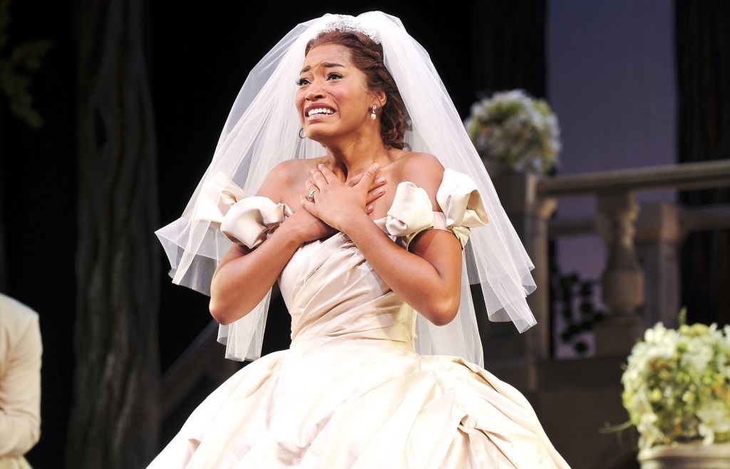 Keke Palmer in a wedding gown and veil on stage, expressing emotion