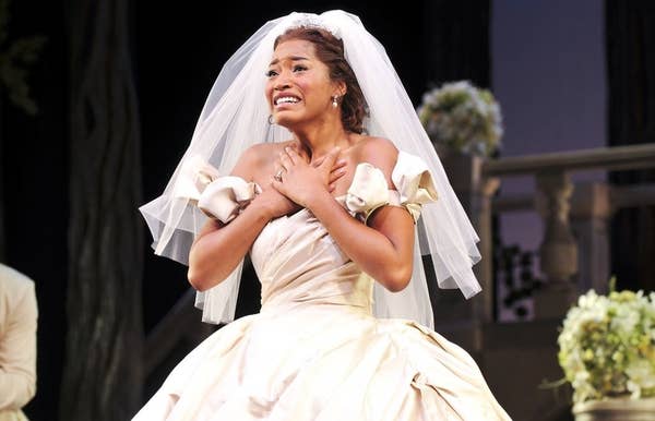 Keke Palmer in a wedding gown and veil on stage, expressing emotion