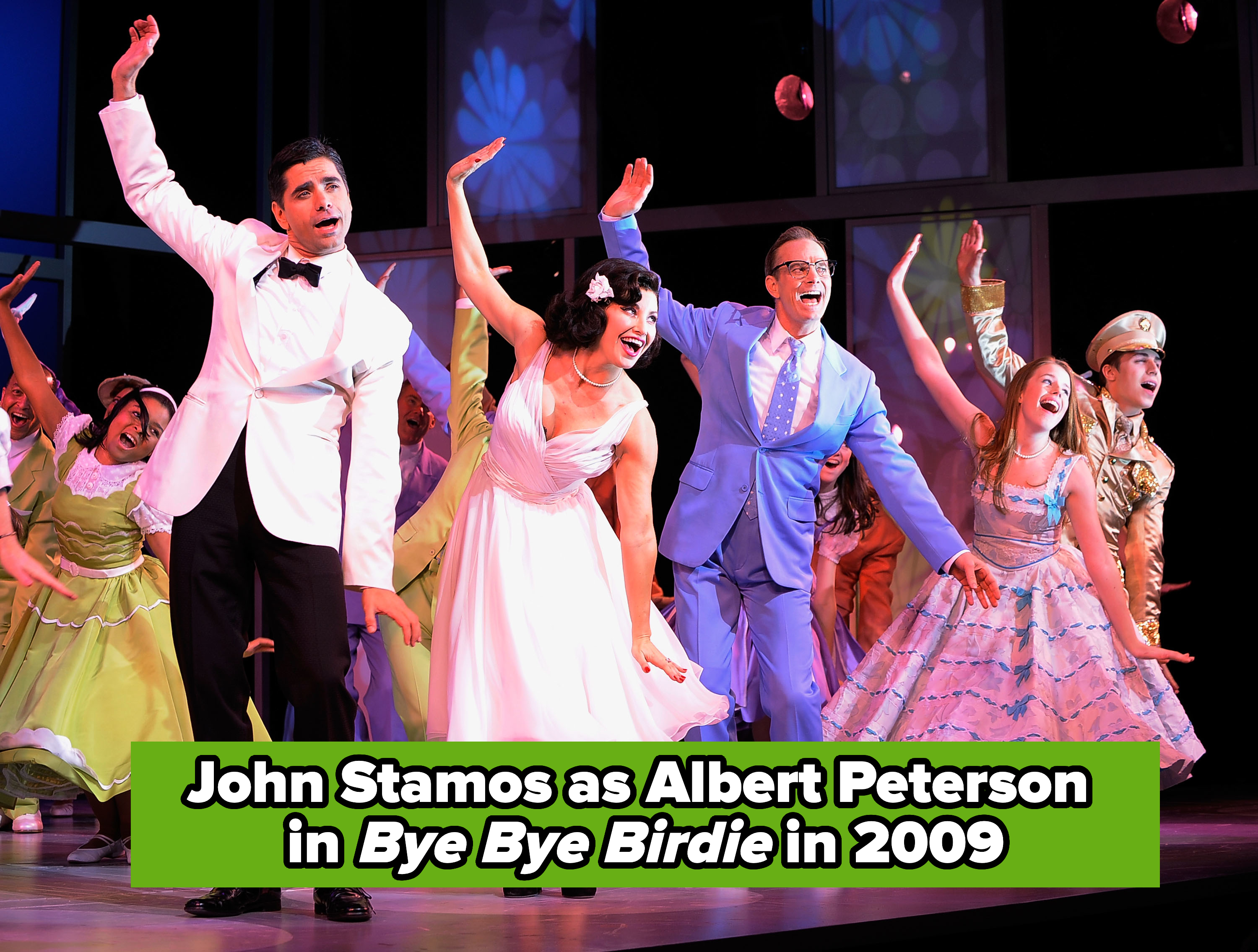 Actors perform energetically in a stage musical, featuring vintage-style costumes with suits and dresses, John on the left in a tux and bowtie, caption "John Stamos as Albert Peterson in Bye Bye Birdie in 2009"