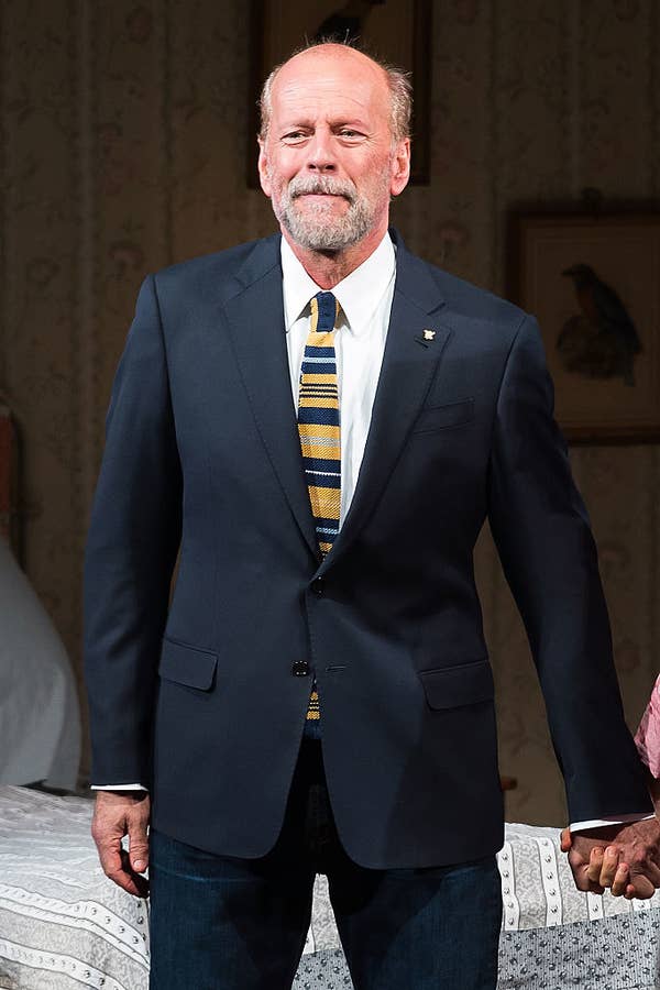 Bruce wearing a formal suit with a striped tie during curtain call
