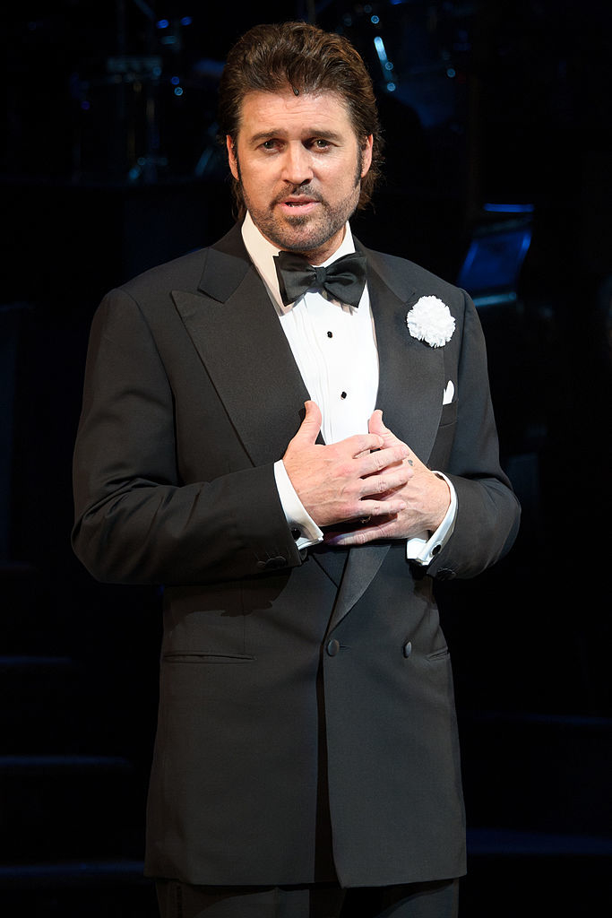 Billy Ray Cyrus in a tux with slicked-back hair onstage