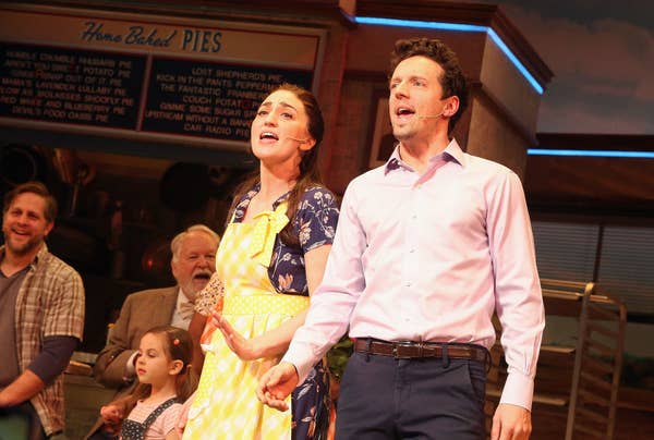 Sara Bareilles in a dress and apron and Jason Mraz in business casual singing onstage on a diner set