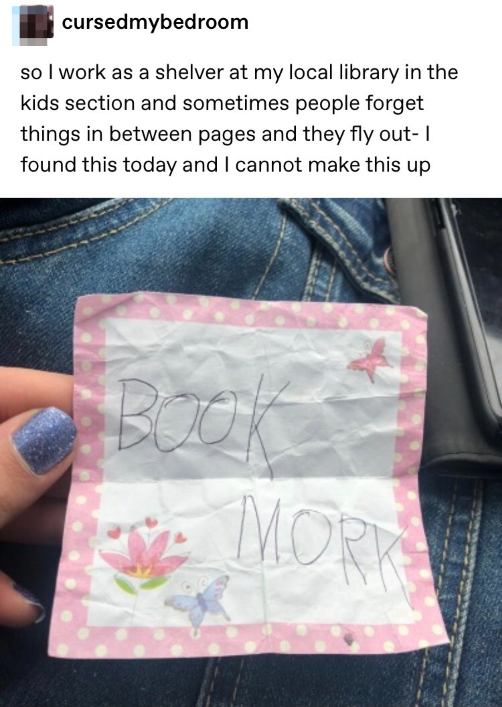 A handwritten note on a piece of paper with &quot;BOOK MORK&quot; and drawings of a flower and butterfly. Person holding the note over jeans