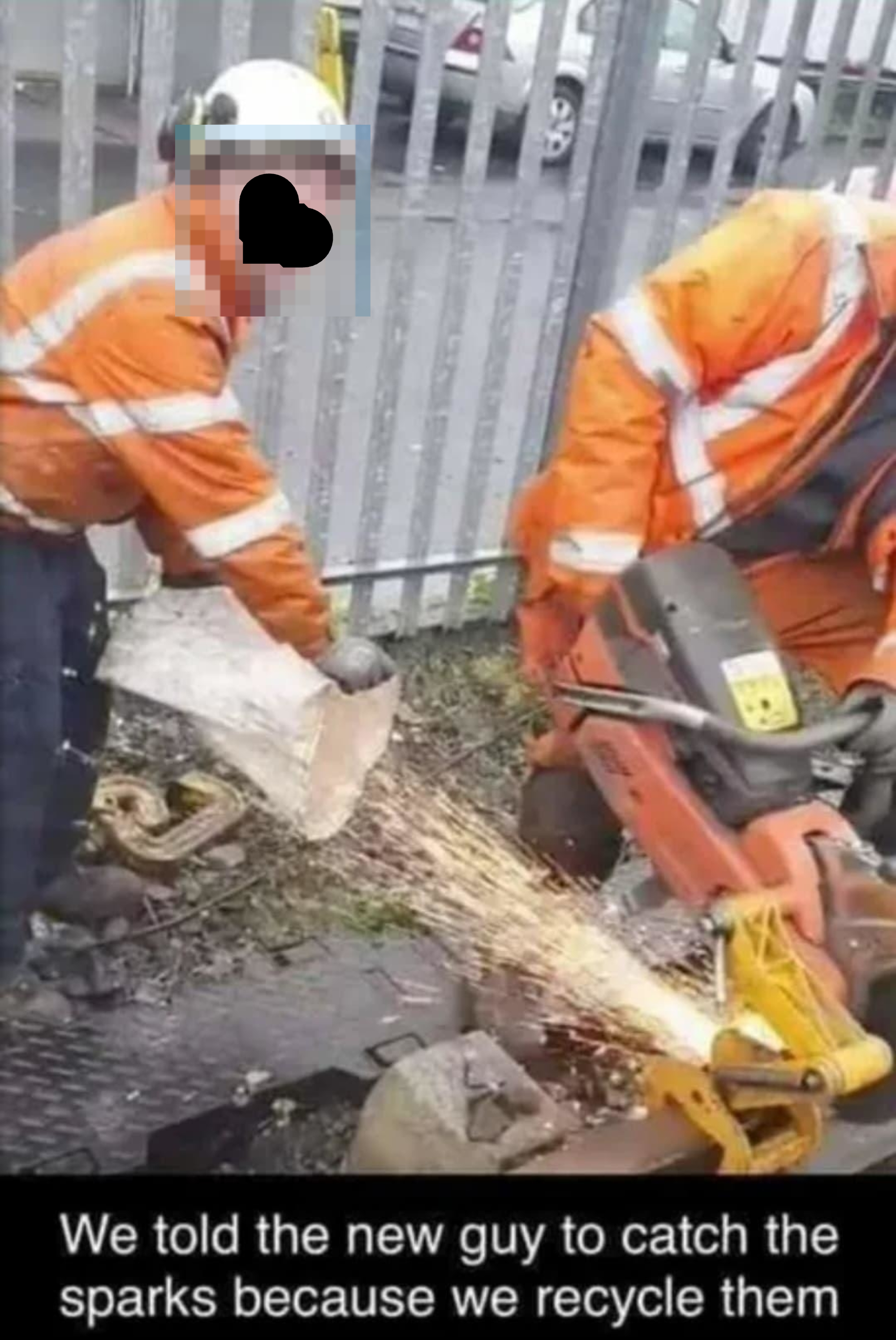 Two workers in orange safety gear; one uses a saw, while the other holds a bag to catch sparks. Text joke: &quot;We told the new guy to catch the sparks.&quot;