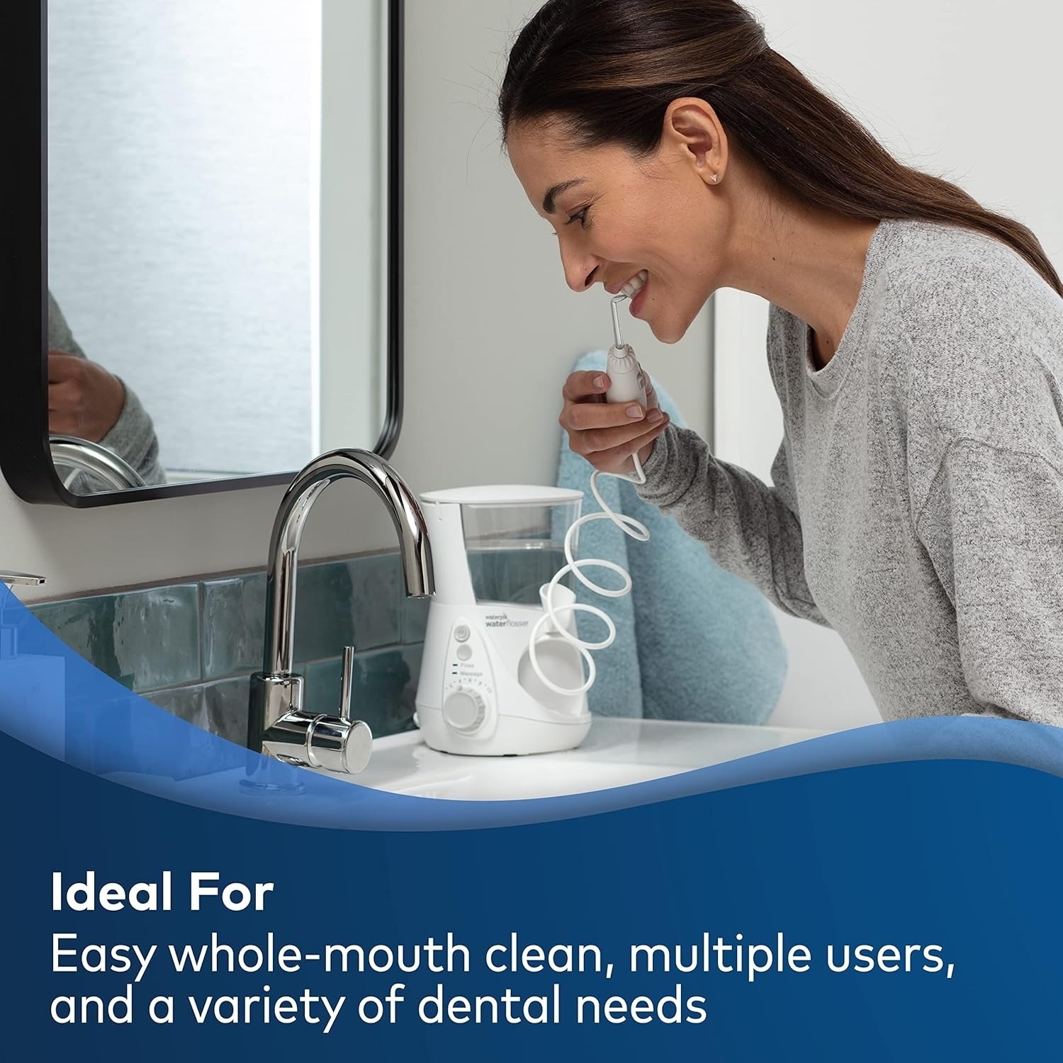 Person using a water flosser in a bathroom. Text: &quot;Ideal For easy whole-mouth clean, multiple users, and a variety of dental needs.&quot;