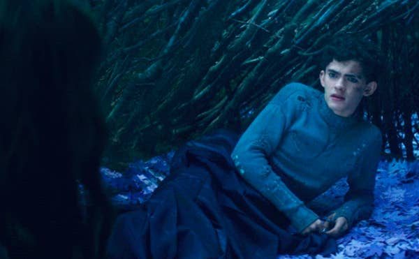 Teen lying on leaves with a coat over his legs in a scene from &quot;Agatha All Along&quot;
