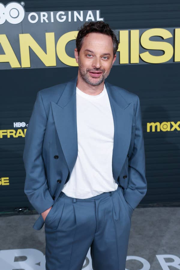 A person in a double-breasted suit stands on a red carpet at an HBO event