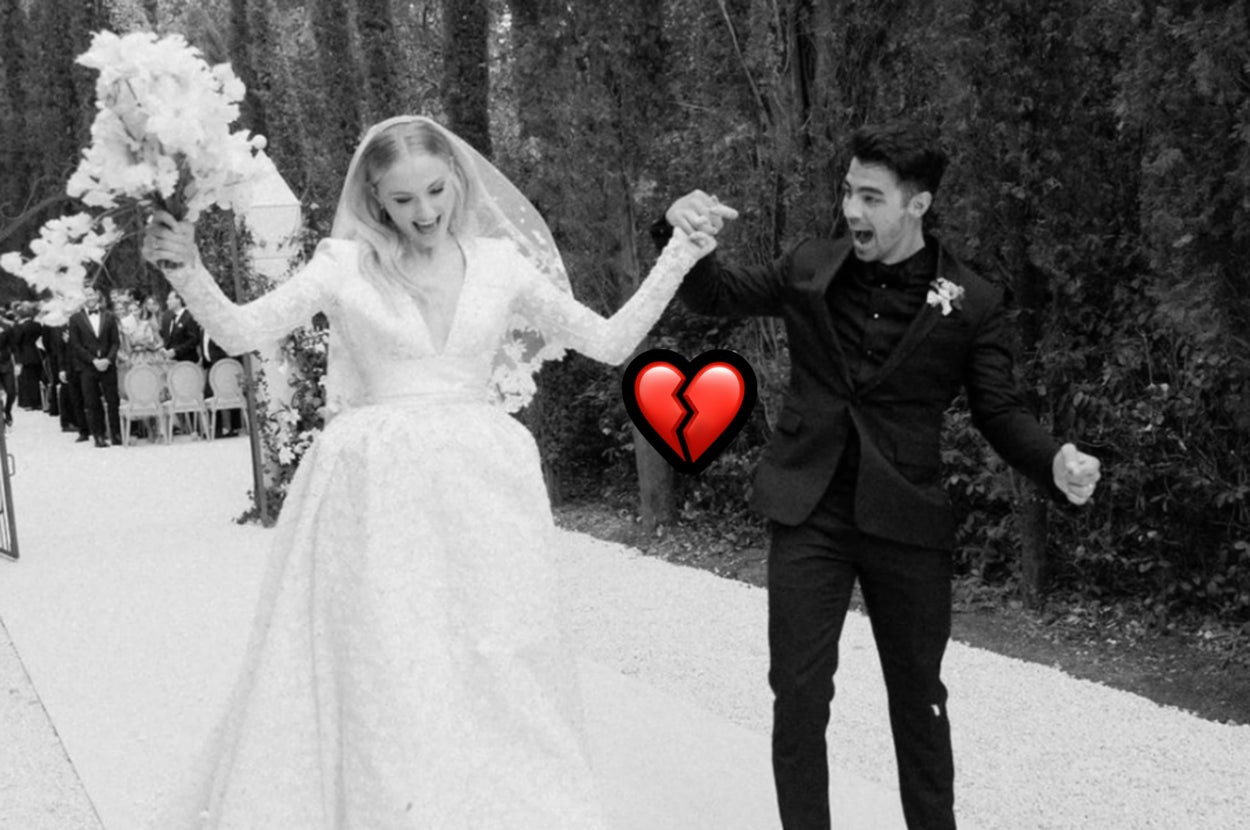 A couple in wedding attire joyfully walks down an outdoor aisle, holding hands and smiling broadly