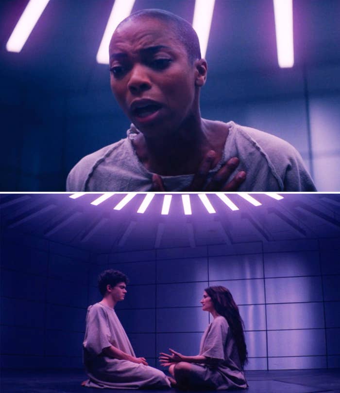 Scene from a TV show featuring a worried person in a futuristic room. Below, two people sit on the floor speaking, surrounded by neon lights