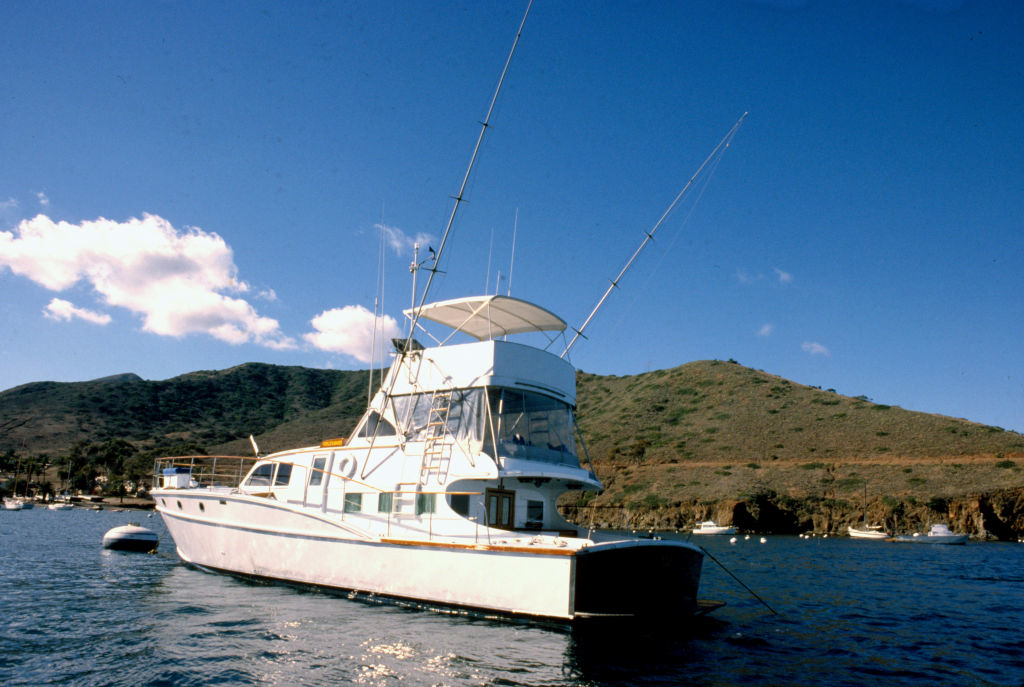 Boat anchored on a scenic lake with hills in the background under a clear sky