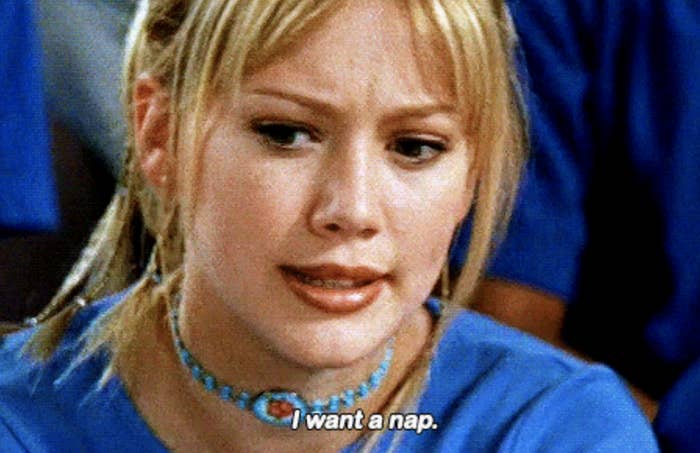 A woman with blonde hair wearing a blue choker looks tired. Text says: 