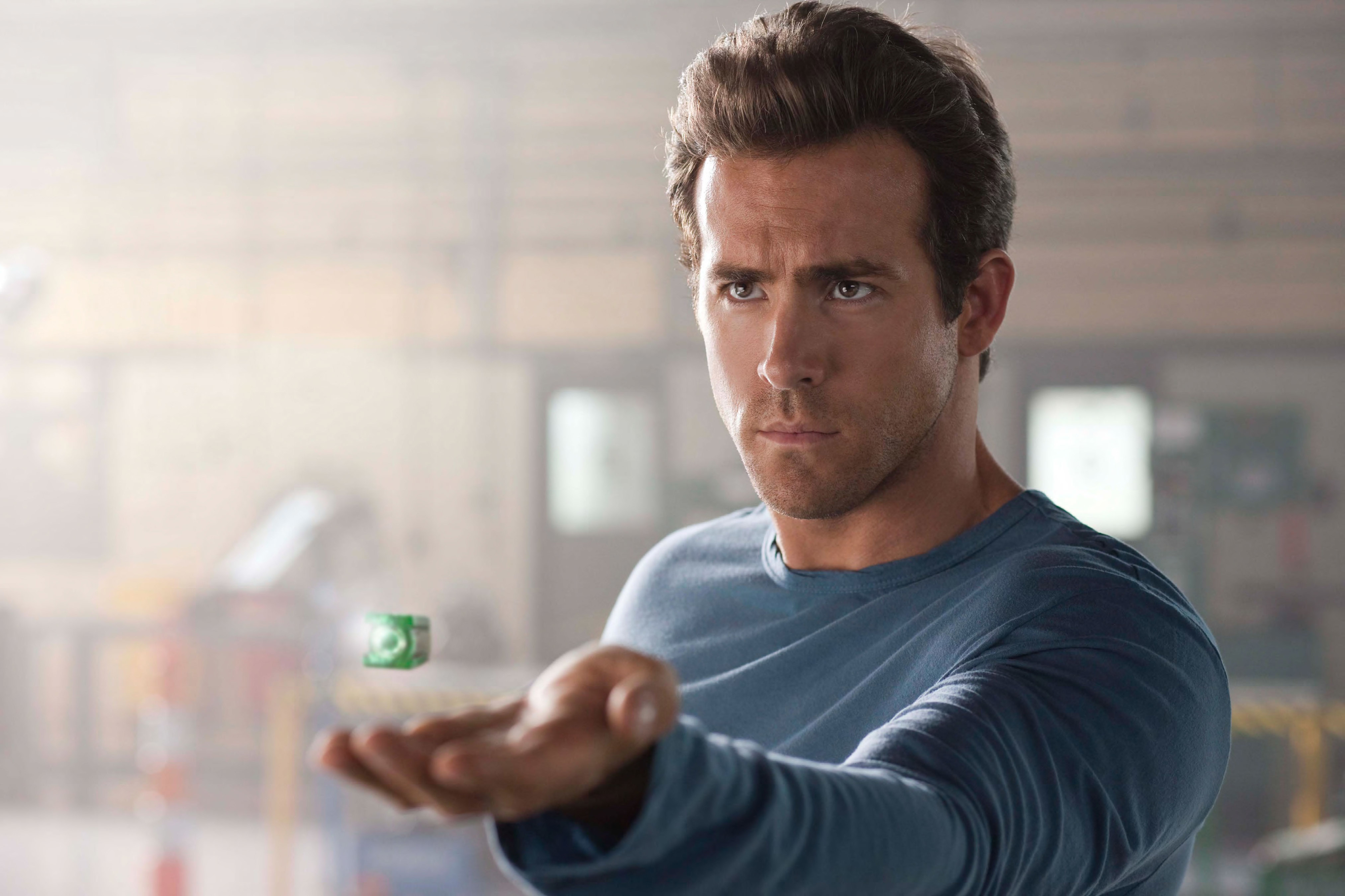 Ryan in a casual long-sleeved shirt staring intensely as a futuristic ring hovers over his open palm