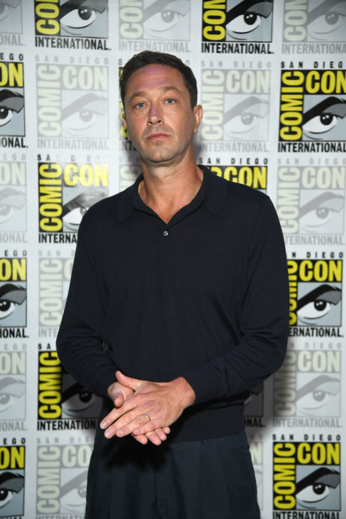 Ebon in a long-sleeved polo and trousers posing at SDCC
