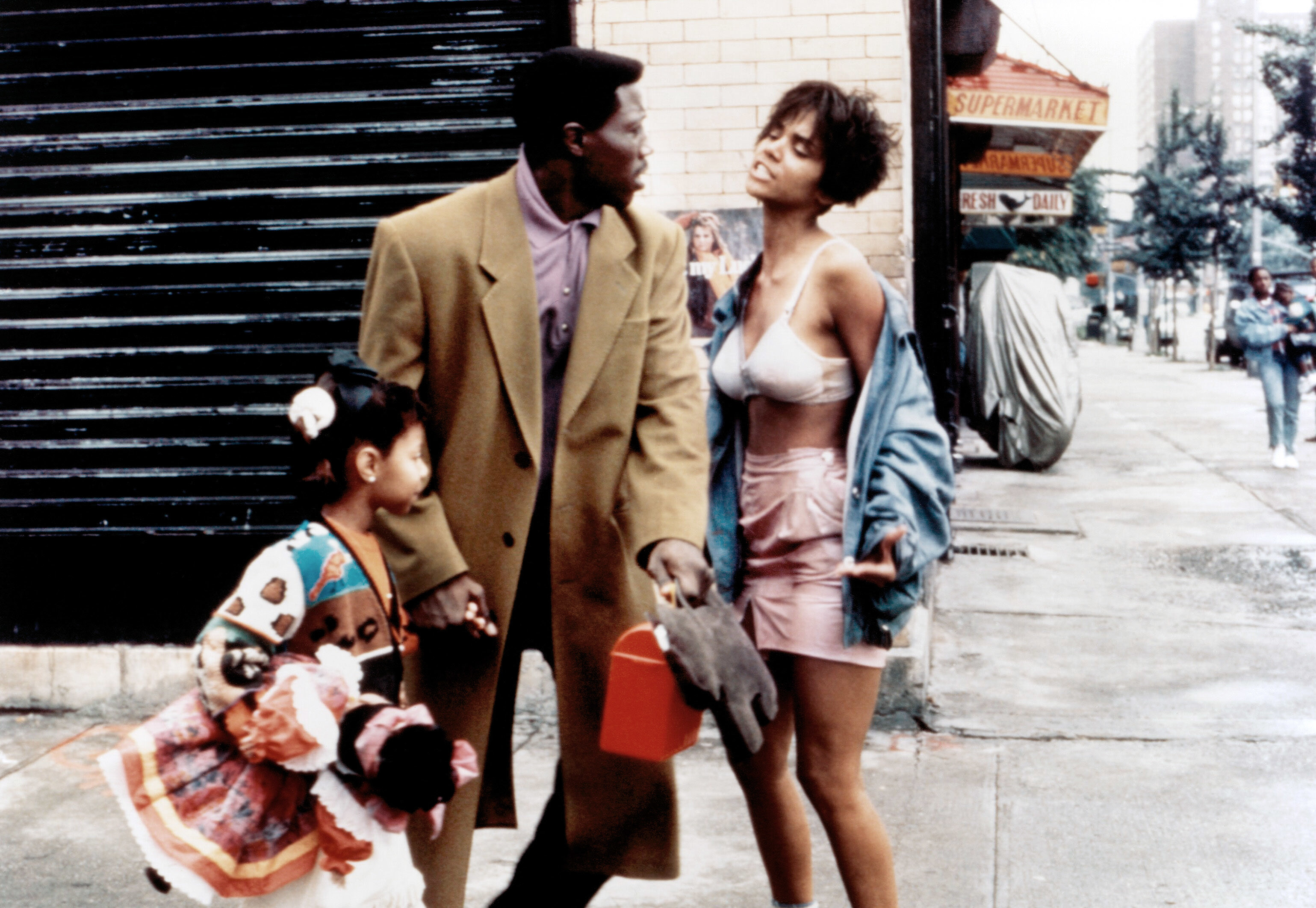 Scene from "Jungle Fever" with Wesley Snipes and Halle Berry on a city street. Halle wears a denim jacket with shorts; Wesley is in a long coat