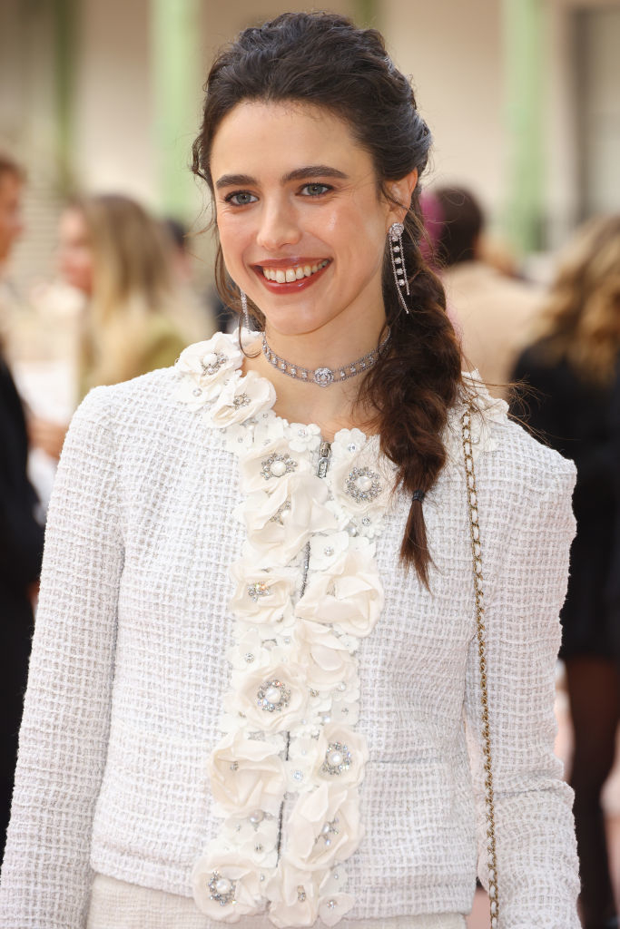 Margaret on the red carpet wearing a texture jacket with floral embellishments and a choker necklace, smiling at the camera