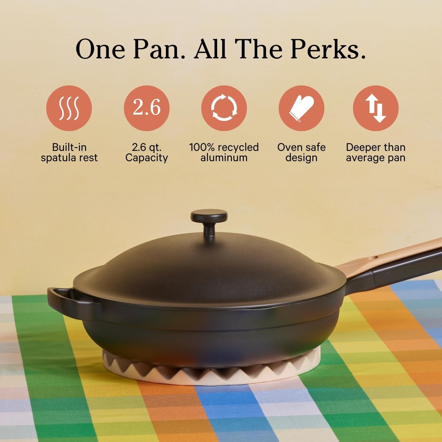 Pan on a table with features listed: built-in spatula rest, 2.6 qt capacity, 100% recycled aluminum, oven safe, deeper than average pan