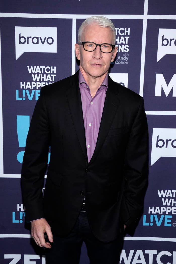 Person in a suit standing against a backdrop with "Watch What Happens Live" logos